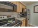 Appliance view in this kitchen with wood cabinets and dark countertops, including a range and microwave at 1710 Belleair Forest Dr # A, Belleair, FL 33756