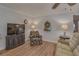 Relaxing living room featuring wood-look floors, ceiling fan, and comfortable furnishings at 1710 Belleair Forest Dr # A, Belleair, FL 33756