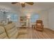Open living and dining area with wood-look floors, and a ceiling fan at 1710 Belleair Forest Dr # A, Belleair, FL 33756