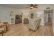 Relaxing living room featuring wood-look floors, ceiling fan, and comfortable furnishings at 1710 Belleair Forest Dr # A, Belleair, FL 33756