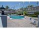 A community pool surrounded by patio furniture and landscaping at 1710 Belleair Forest Dr # A, Belleair, FL 33756