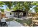 Backyard with a covered patio area that includes barstool seating, a grill and dining seating on the paved area at 1851 Oklahoma Ne Ave, St Petersburg, FL 33703