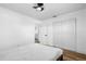 Neutral bedroom featuring hardwood floors, ceiling fan, closet, and doorway to bathroom at 1851 Oklahoma Ne Ave, St Petersburg, FL 33703