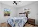 Bright bedroom with hardwood floors, ceiling fan, and a blue-and-white bedspread at 1851 Oklahoma Ne Ave, St Petersburg, FL 33703