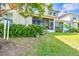 Backyard of home featuring screened-in porch and privacy hedges at 1962 Marlington Way, Clearwater, FL 33763