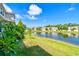 Backyard view of pond in community with manicured lawns and community landscaping at 1962 Marlington Way, Clearwater, FL 33763
