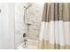 Bright bathroom features a shower over tub and modern white marble-look tile at 1962 Marlington Way, Clearwater, FL 33763