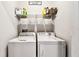 Bright laundry room featuring a washer and dryer set, overhead storage, and modern design at 1962 Marlington Way, Clearwater, FL 33763