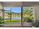 Screened in porch view of pond and manicured lawns of neighboring houses at 1962 Marlington Way, Clearwater, FL 33763