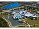 Aerial view of a community center with pools, tennis courts, and a large lake at 19652 Ship Wheel Way, Land O Lakes, FL 34638