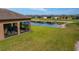 Backyard view of a grassy yard and a pond with a walkway in a residential neighborhood at 19652 Ship Wheel Way, Land O Lakes, FL 34638