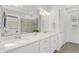 Bright bathroom featuring dual sinks with quartz countertops and a glass-enclosed shower at 19652 Ship Wheel Way, Land O Lakes, FL 34638