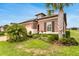 Attractive home exterior with lush landscaping, featuring a palm tree and well-kept lawn at 19652 Ship Wheel Way, Land O Lakes, FL 34638