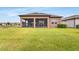 Green backyard and screened porch area, with views of the lake beyond at 19652 Ship Wheel Way, Land O Lakes, FL 34638