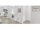 Open hallway with light wood floors, doors to the living room, and stylish decor at 19652 Ship Wheel Way, Land O Lakes, FL 34638