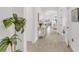 Bright hallway featuring wood floors, an accent table, and views into the dining and living areas at 19652 Ship Wheel Way, Land O Lakes, FL 34638