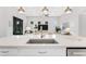 Close up of a kitchen island with a sink, stainless steel appliances, and an open living space at 19652 Ship Wheel Way, Land O Lakes, FL 34638