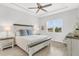 Serene main bedroom with tray ceiling, wood-look tile flooring, and window with backyard view at 19652 Ship Wheel Way, Land O Lakes, FL 34638