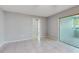 Spacious bedroom features tile flooring, neutral walls, and a sliding glass door leading to a sunroom at 2138 Viola Dr, Clearwater, FL 33764