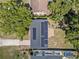 An aerial view of a home's roof with installed solar panels, surrounded by mature trees and green lawns at 2426 17Th N Ave, St Petersburg, FL 33713
