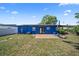 Blue home's backyard featuring a green lawn, patio, and basketball hoop, perfect for outdoor activities at 2426 17Th N Ave, St Petersburg, FL 33713