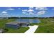 Stunning aerial view of a modern home with a long driveway, nestled beside a serene lake and lush green lawn at 2426 Hiers Rd, Dover, FL 33527