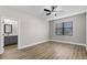 A bedroom with wood flooring, a ceiling fan, a window and a door to an attached bathroom at 2426 Hiers Rd, Dover, FL 33527