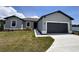 Charming single-story home featuring a two-car garage, well-maintained lawn, and neutral gray color palette at 2426 Hiers Rd, Dover, FL 33527