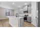 Bright kitchen with gray cabinets, stainless steel appliances, center island, tile backsplash, and modern fixtures at 2426 Hiers Rd, Dover, FL 33527