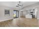 Bright, open-concept living space with wood-look floors, ceiling fan and sliding glass doors to the backyard at 2426 Hiers Rd, Dover, FL 33527