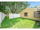A serene backyard featuring lush green grass, a storage shed, and enclosed with a white vinyl fence at 3072 Sugar Bear Trl, Palm Harbor, FL 34684