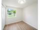 Bedroom showcasing wood-look flooring and a window with views of a well-maintained lawn at 3072 Sugar Bear Trl, Palm Harbor, FL 34684