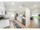Updated kitchen with white cabinets, stainless steel appliances, and an open view to the living room at 3072 Sugar Bear Trl, Palm Harbor, FL 34684