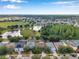 Expansive aerial view showcasing the neighborhood, nearby lakes, lush greenery, and community amenities at 3230 Bellericay Ln, Land O Lakes, FL 34638