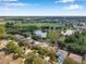 An aerial view of homes surrounding a lake and a spacious park, showcasing a community's green spaces at 3230 Bellericay Ln, Land O Lakes, FL 34638