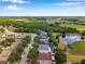 This aerial view looks down a street highlighting backyards, pools and a green space with a pond in the background at 3230 Bellericay Ln, Land O Lakes, FL 34638