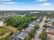 A community view with lush green trees, a lake, and well-maintained homes lining the street at 3230 Bellericay Ln, Land O Lakes, FL 34638