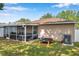 Rear exterior view of the house with a screened patio, backyard, and well-maintained landscaping at 3230 Bellericay Ln, Land O Lakes, FL 34638