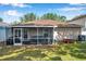 Exterior view of the home showcasing the screened patio, well-maintained lawn, and backyard features at 3230 Bellericay Ln, Land O Lakes, FL 34638
