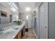 Bright bathroom featuring a long vanity with white countertops and wood-look flooring at 3230 Bellericay Ln, Land O Lakes, FL 34638