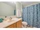Bathroom with a floral-patterned shower curtain and a vanity with a light wood cabinet at 3230 Bellericay Ln, Land O Lakes, FL 34638