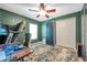 Study room with a dark green wall, a ceiling fan, and a desk with a treadmill at 3230 Bellericay Ln, Land O Lakes, FL 34638