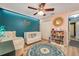 Lovely Bedroom featuring a crib, accent wall, ceiling fan and a round blue patterned rug at 3230 Bellericay Ln, Land O Lakes, FL 34638
