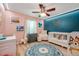 Charming Bedroom with pink walls, teal accent wall, crib, rocking chair, and a round area rug at 3230 Bellericay Ln, Land O Lakes, FL 34638