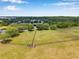Aerial view of a fenced dog park with a pond and lush landscaping on a sunny day at 3230 Bellericay Ln, Land O Lakes, FL 34638