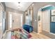 Bright foyer with a large front door, colorful rug, and decorative blue bench at 3230 Bellericay Ln, Land O Lakes, FL 34638