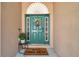 Inviting front door with colorful wreath, decorative sidelights and a cute welcome mat at 3230 Bellericay Ln, Land O Lakes, FL 34638