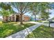 Inviting home exterior with manicured lawn, mature trees, and a two-car garage at 3230 Bellericay Ln, Land O Lakes, FL 34638