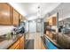 Modern kitchen with wood cabinets, stainless steel appliances, and granite countertops at 3230 Bellericay Ln, Land O Lakes, FL 34638