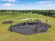 This aerial image captures a large, well maintained playground with multiple play areas and green landscaping at 3230 Bellericay Ln, Land O Lakes, FL 34638